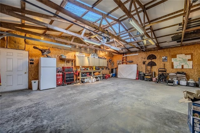 garage with a workshop area and freestanding refrigerator