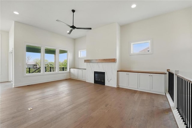 1518 NW 106th Ter, Kansas City, MO 64155 - unfurnished living room with light wood-style floors, a high end fireplace, ceiling fan, and recessed lighting