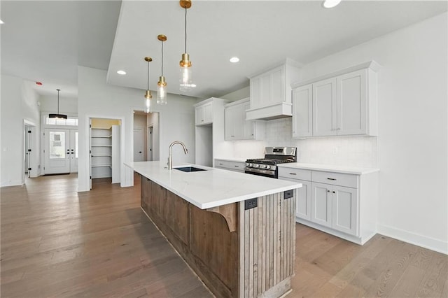1518 NW 106th Ter, Kansas City, MO 64155 - kitchen featuring stainless steel range with gas stovetop, custom range hood, light wood finished floors, recessed lighting, and tasteful backsplash