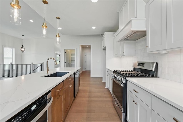 1518 NW 106th Ter, Kansas City, MO 64155 - kitchen featuring appliances with stainless steel finishes, premium range hood, decorative backsplash, light wood-style flooring, and white cabinetry