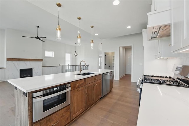 1518 NW 106th Ter, Kansas City, MO 64155 - kitchen featuring stainless steel appliances, ceiling fan, light wood-style floors, an island with sink, and recessed lighting