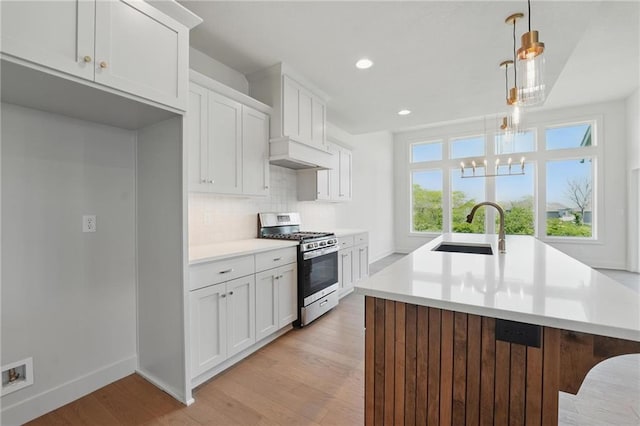1518 NW 106th Ter, Kansas City, MO 64155 - kitchen featuring stainless steel range with gas stovetop, light wood finished floors, plenty of natural light, light countertops, and recessed lighting