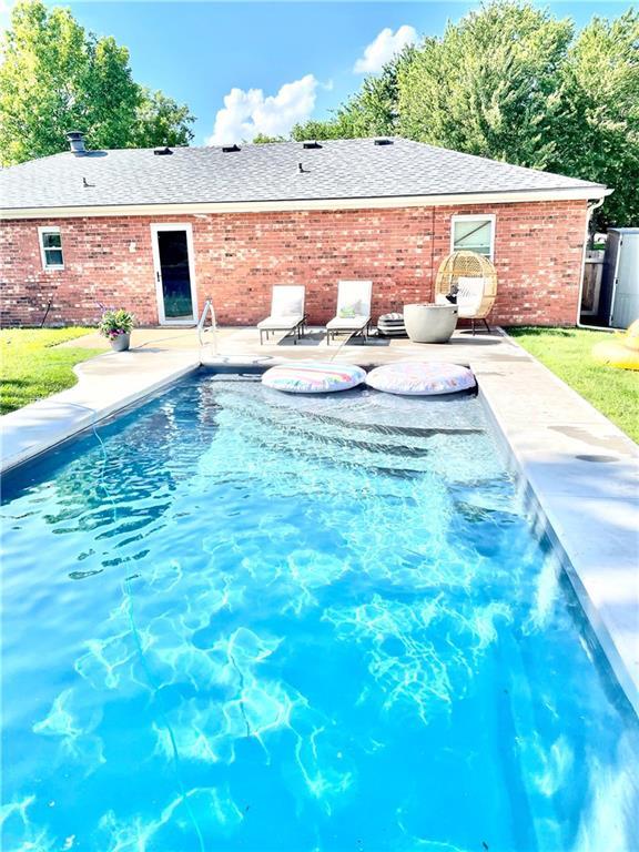 view of swimming pool featuring a lawn and a patio