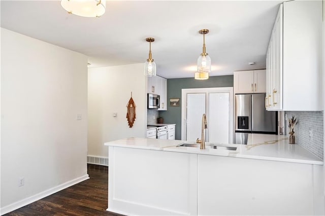 kitchen featuring visible vents, stainless steel appliances, a sink, dark wood-type flooring, and tasteful backsplash