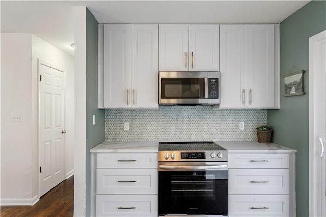 kitchen featuring tasteful backsplash, appliances with stainless steel finishes, dark wood-style flooring, and white cabinetry