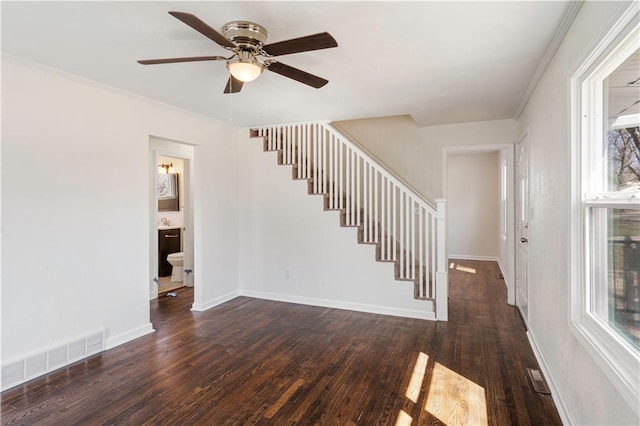 stairway with baseboards, wood finished floors, visible vents, and ceiling fan