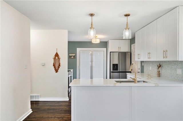 kitchen featuring tasteful backsplash, visible vents, stainless steel fridge with ice dispenser, white cabinetry, and a sink