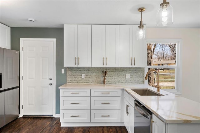 kitchen featuring dark wood-style floors, a sink, decorative backsplash, white cabinets, and appliances with stainless steel finishes