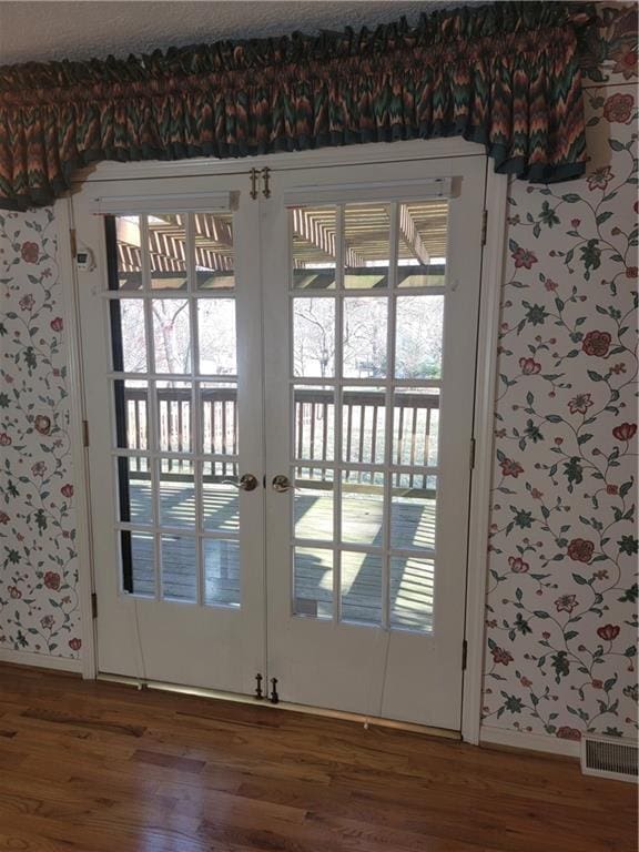 doorway to outside with visible vents and wood finished floors