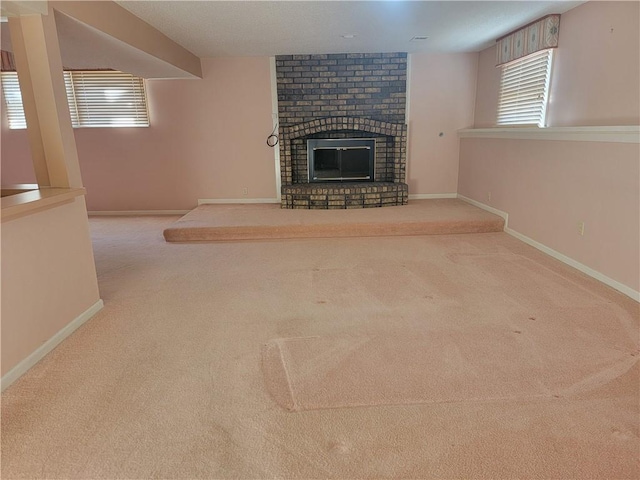 unfurnished living room featuring a fireplace, baseboards, and carpet floors