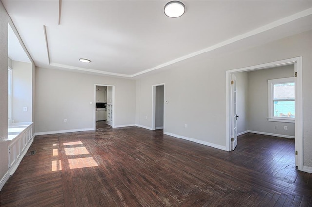 spare room with dark wood-type flooring and baseboards