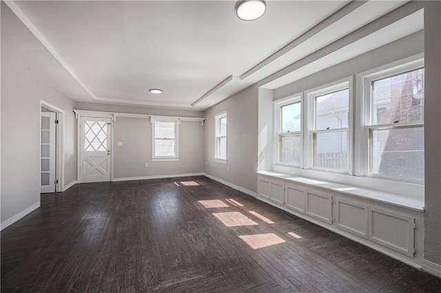 interior space with dark wood-type flooring and baseboards