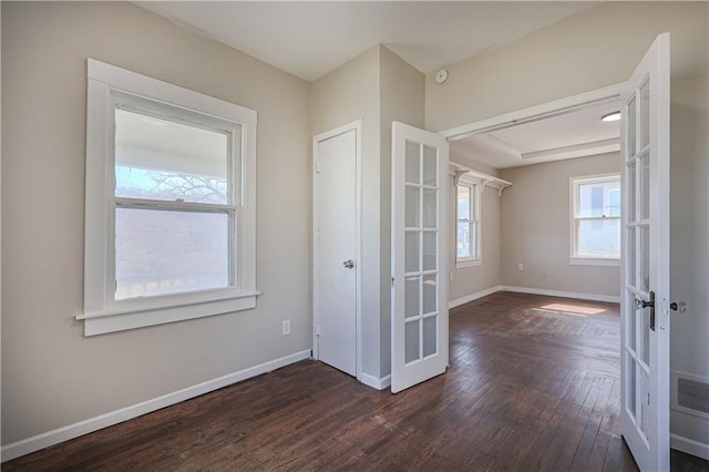 interior space featuring dark wood finished floors, french doors, and baseboards