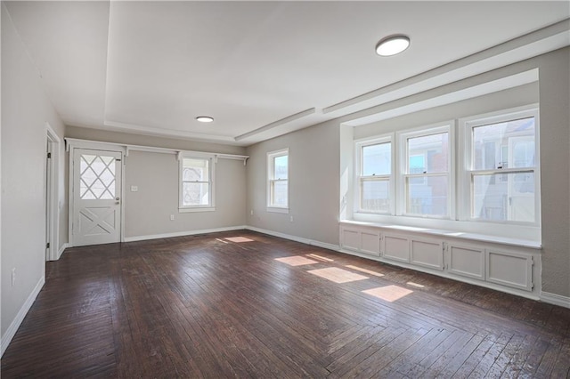 spare room featuring baseboards and dark wood-type flooring