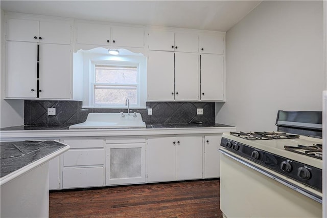 kitchen featuring a sink, gas range gas stove, dark wood-style flooring, and white cabinetry