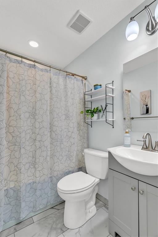 full bath with visible vents, toilet, marble finish floor, and vanity