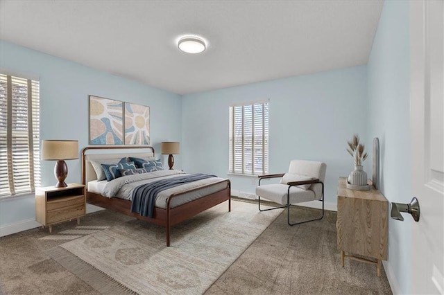 bedroom with multiple windows, baseboards, and carpet