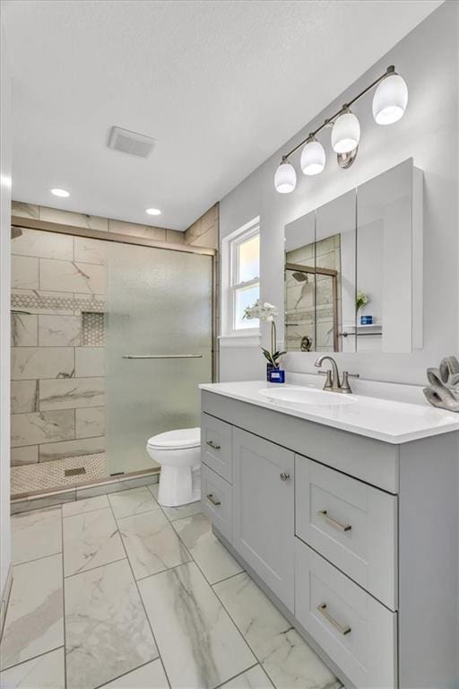 bathroom with vanity, a shower stall, toilet, and marble finish floor