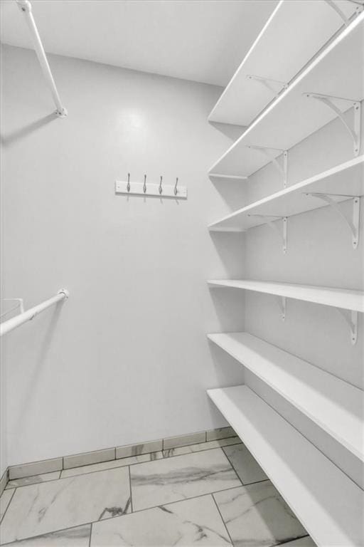 spacious closet featuring marble finish floor