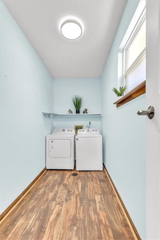 laundry room featuring laundry area, wood finished floors, separate washer and dryer, and baseboards