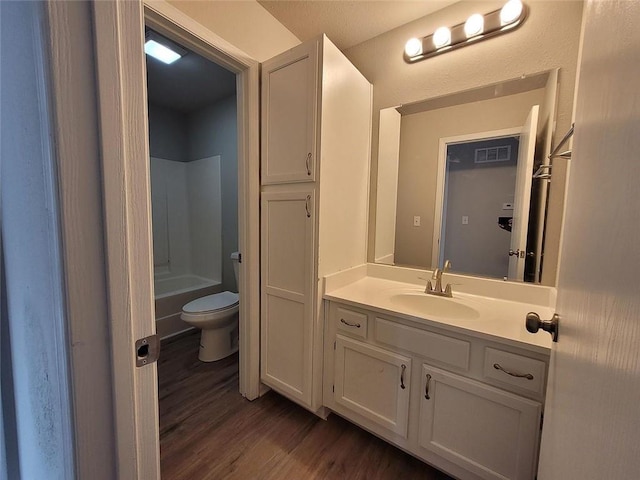 bathroom with vanity, wood finished floors, visible vents, shower / bath combination, and toilet