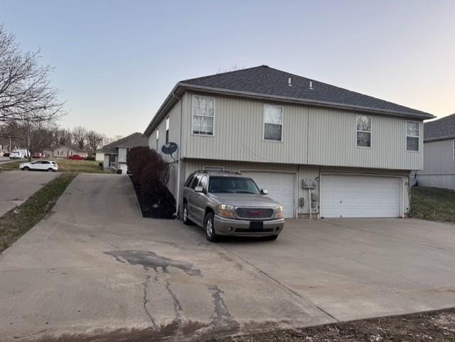 view of property exterior with a garage and concrete driveway