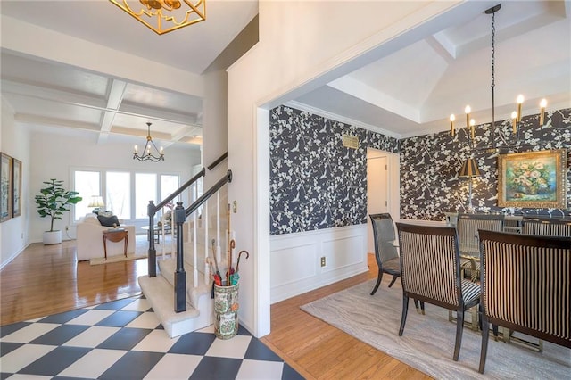 dining area featuring wallpapered walls, beamed ceiling, wainscoting, an inviting chandelier, and coffered ceiling