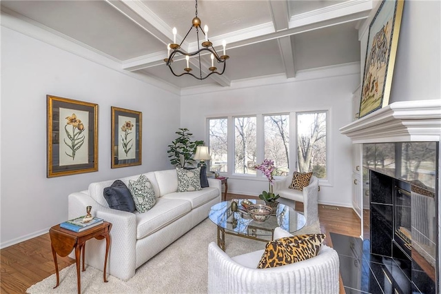 living area with a fireplace, an inviting chandelier, wood finished floors, and baseboards