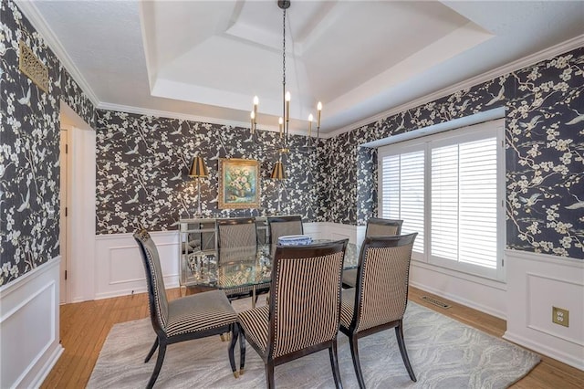 dining room featuring visible vents, wainscoting, wallpapered walls, and a tray ceiling