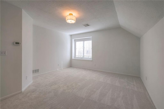 additional living space featuring visible vents, lofted ceiling, carpet, and baseboards