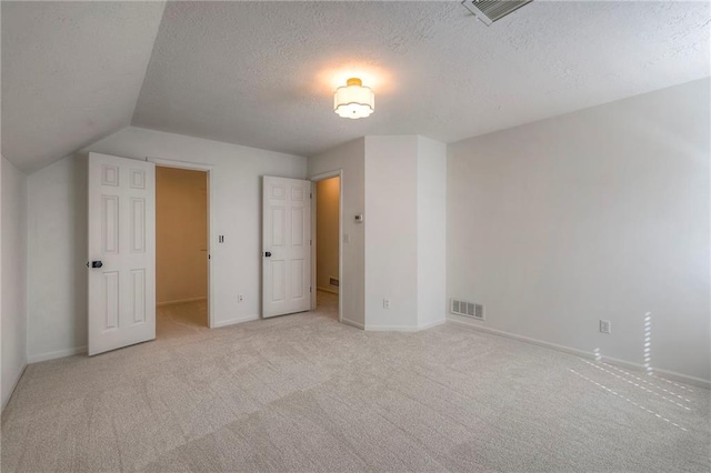 unfurnished bedroom with visible vents, carpet, and a textured ceiling