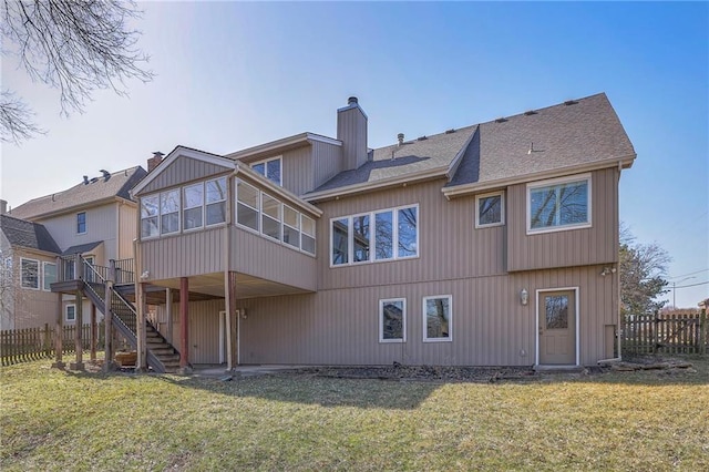 back of property featuring a lawn, stairs, fence, a sunroom, and a chimney