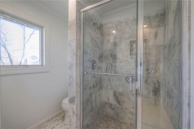 bathroom featuring crown molding, toilet, baseboards, and a stall shower