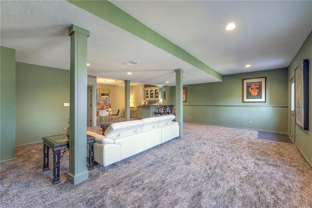 living room featuring a textured ceiling, recessed lighting, carpet, decorative columns, and baseboards