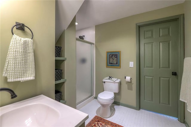 bathroom featuring tile patterned floors, toilet, a stall shower, a sink, and baseboards