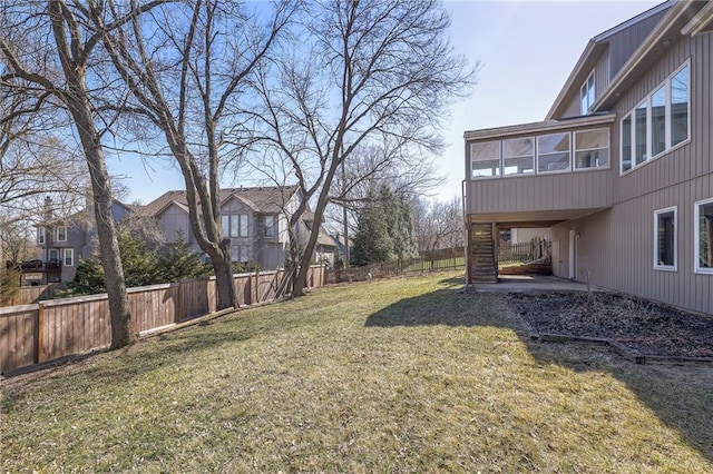 view of yard featuring a residential view, fence private yard, and a sunroom