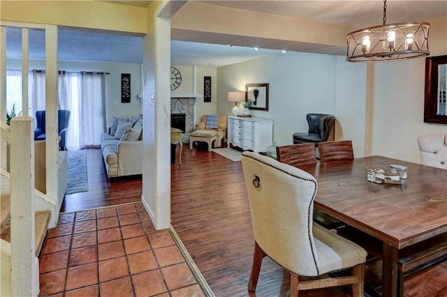 dining room featuring a chandelier, a fireplace, and wood finished floors