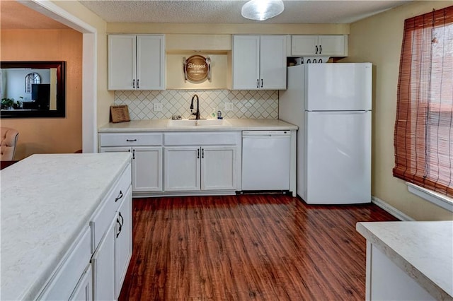 kitchen featuring white appliances, light countertops, dark wood-style flooring, and a sink