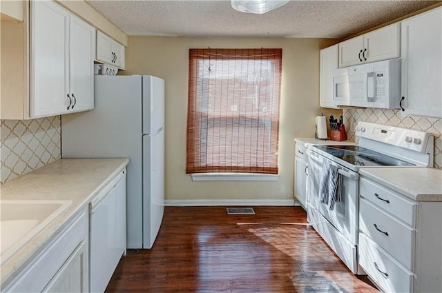 kitchen with visible vents, dark wood-type flooring, white cabinetry, white appliances, and light countertops