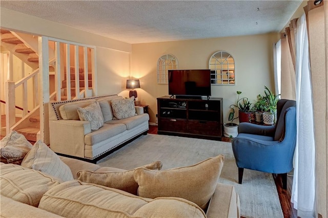 living room featuring a textured ceiling and stairs