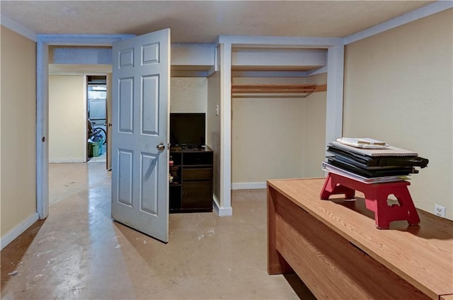 bedroom featuring a closet, unfinished concrete floors, and baseboards