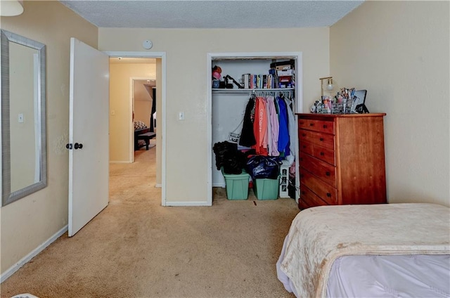 carpeted bedroom featuring a closet, a textured ceiling, and baseboards