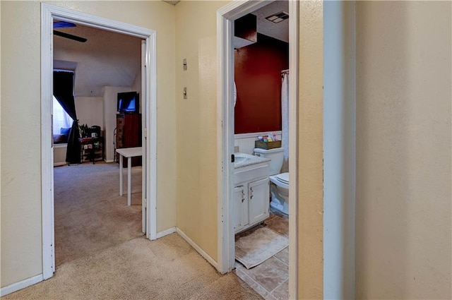 hallway featuring visible vents and light colored carpet