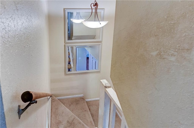 stairs with baseboards, carpet flooring, and a textured wall