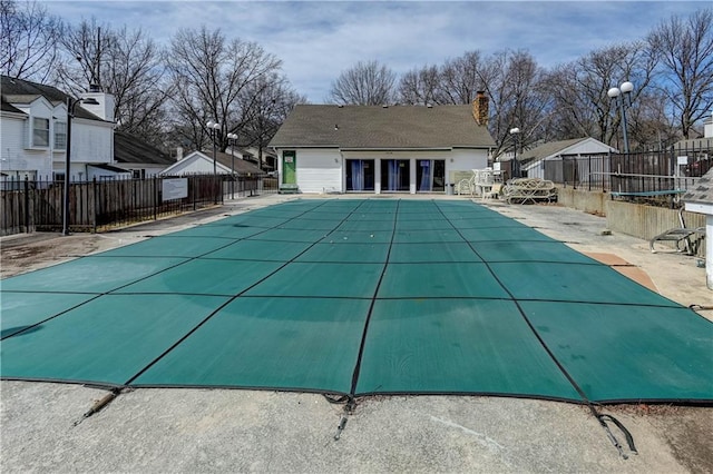 community pool with a patio area and fence