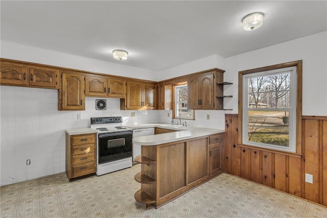 kitchen featuring open shelves, electric range, a peninsula, light countertops, and a wealth of natural light