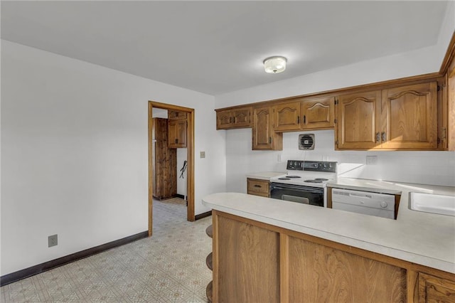 kitchen featuring baseboards, dishwasher, light countertops, a peninsula, and electric stove