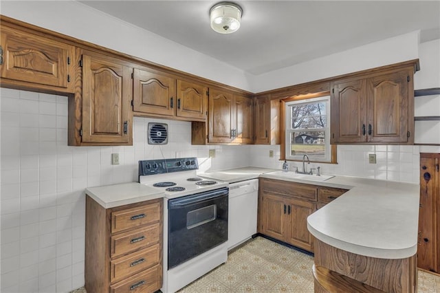 kitchen with light floors, a sink, range with electric cooktop, light countertops, and dishwasher