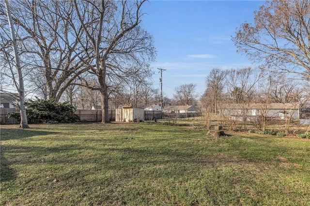 view of yard with an outbuilding, a storage unit, and fence