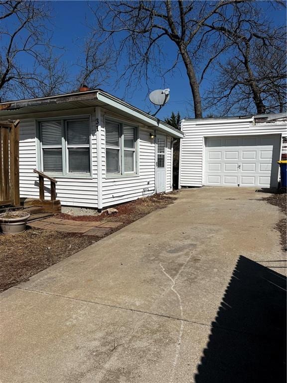 view of front facade with a garage, an outdoor structure, and driveway